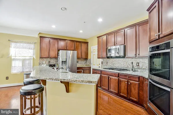 a kitchen with stainless steel appliances granite countertop a stove a sink and a refrigerator