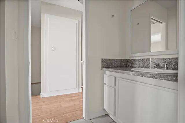 a bathroom with a granite countertop sink and a vanity