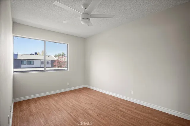 an empty room with wooden floor and window