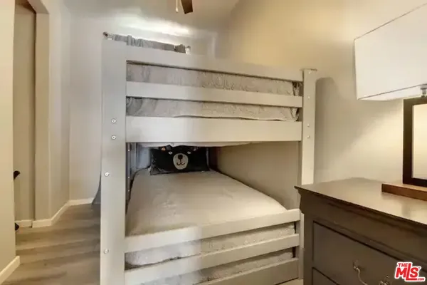 a bedroom with a bed and a lamp on the dresser