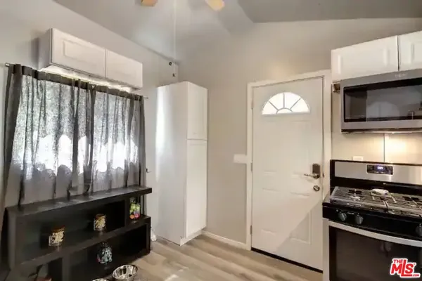 a kitchen with granite countertop a refrigerator and a stove top oven