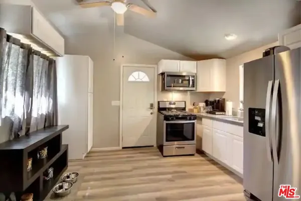 a kitchen with stainless steel appliances granite countertop a refrigerator stove and sink