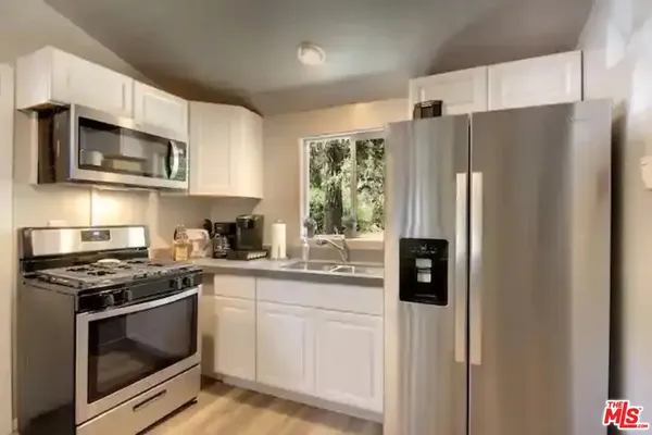 a kitchen with stainless steel appliances a refrigerator stove and microwave