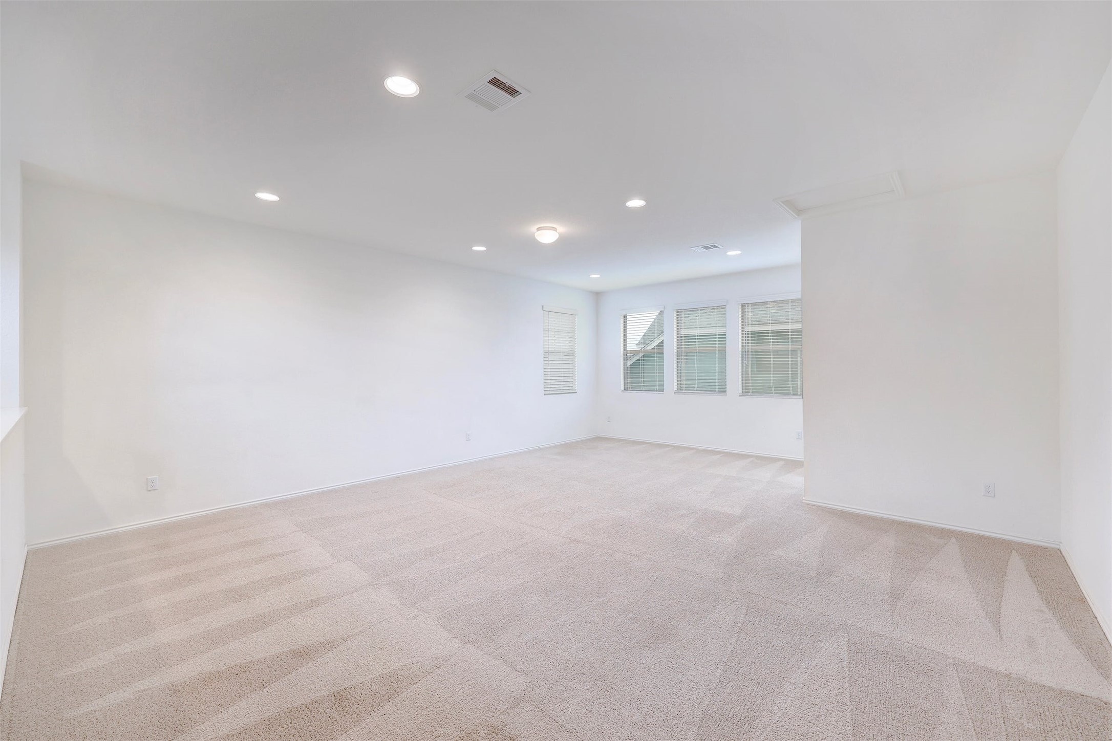307 Simmental Loop Hutto, TX 78634 - Photo 25 of 34 Recessed lighting and plentiful windows illuminate this adaptable bonus room, offering a neutral palette for personalized decor.