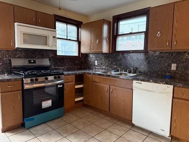 a kitchen with granite countertop cabinets stainless steel appliances and a sink