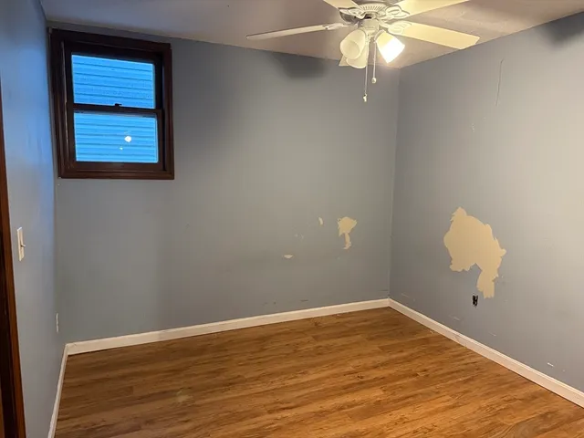 a view of a room with wooden floor and fan