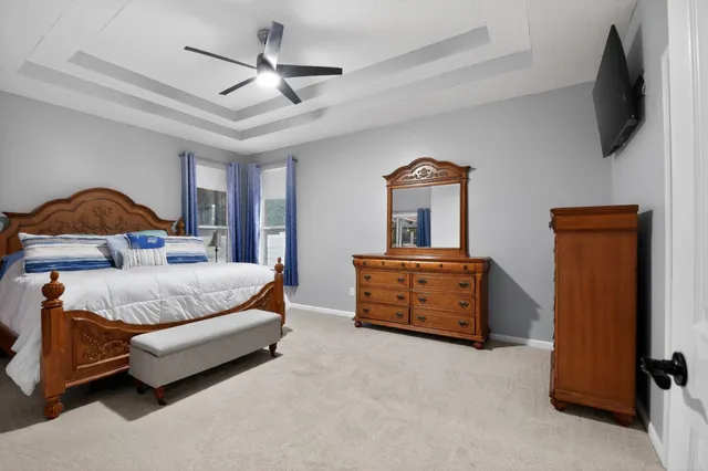 a bedroom with a bed and a flat tv screen on dresser