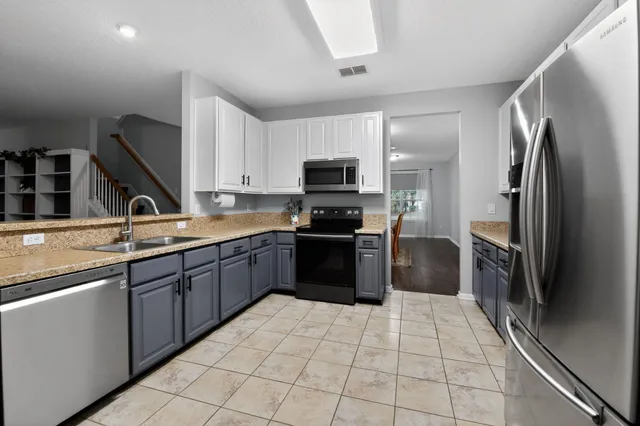 a kitchen with stainless steel appliances granite countertop a refrigerator and a sink