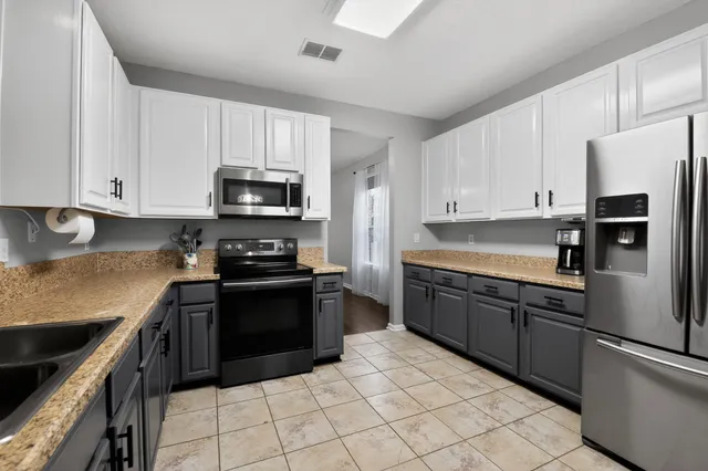 a kitchen with granite countertop a stove sink and cabinets