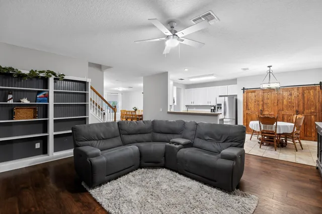 a living room with furniture kitchen view and a window
