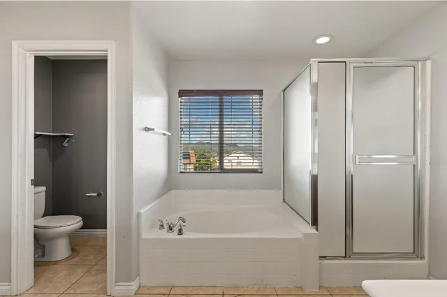 a bathroom with a tub a toilet and a shower