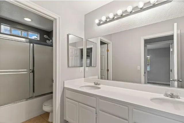 a bathroom with a sink double vanity and a mirror