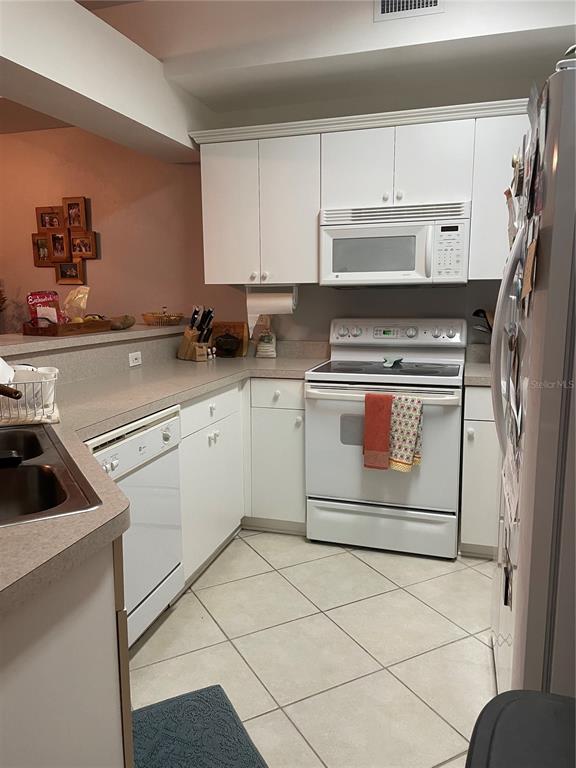 4945 Northwest 1st Place Gainesville, FL 32607 - Photo 6 of 9 a kitchen with cabinets a washer and dryer
