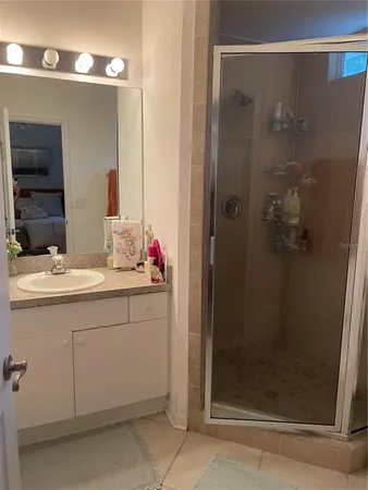 a bathroom with a shower sink and mirror