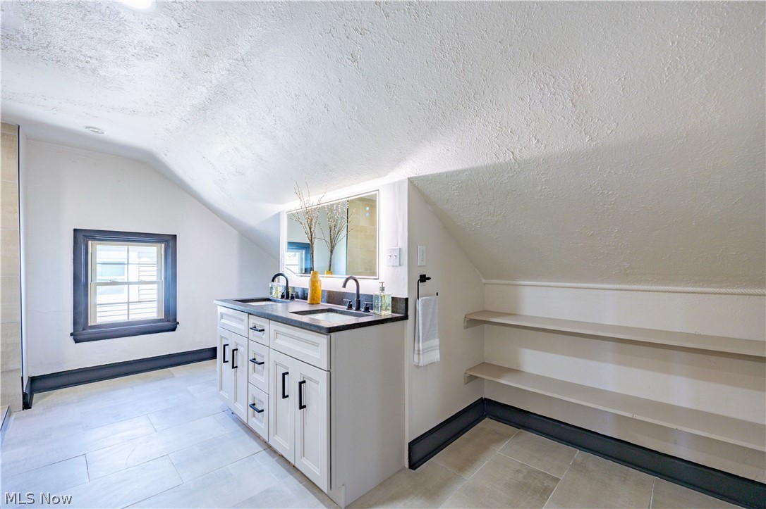 3254 Redwood Road Cleveland Heights, OH 44118 - Photo 27 of 49 Additional living space with a textured ceiling, light tile flooring, sink, and lofted ceiling