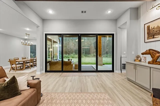 a kitchen with stainless steel appliances granite countertop a stove a refrigerator and a dining table with wooden cabinet