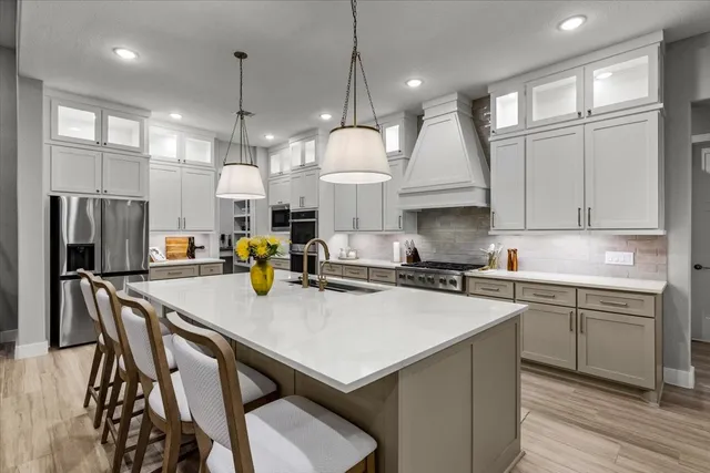 a kitchen with stainless steel appliances granite countertop a sink a stove and a refrigerator