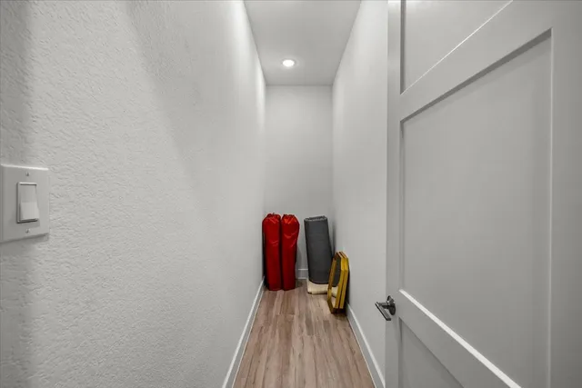 a view of a hallway with wooden floor and staircase