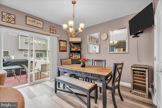 a dining room with wooden floor a chandelier a wooden table and chairs