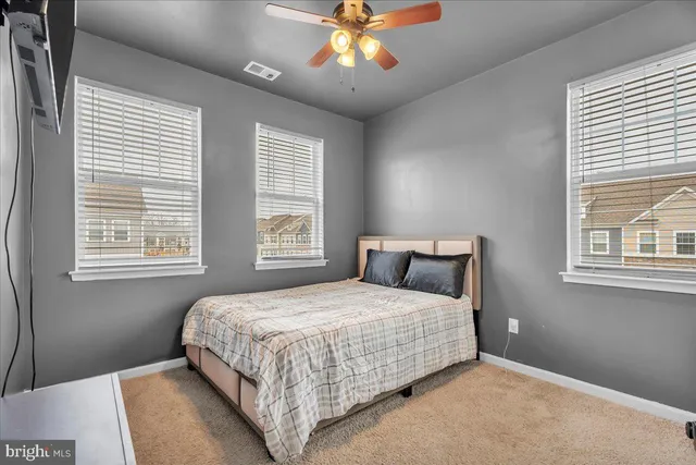 a bedroom with a large bed chandelier and a window