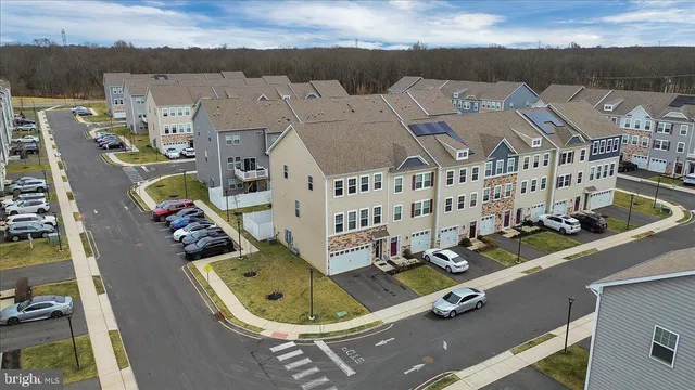 an aerial view of residential houses with outdoor space and parking