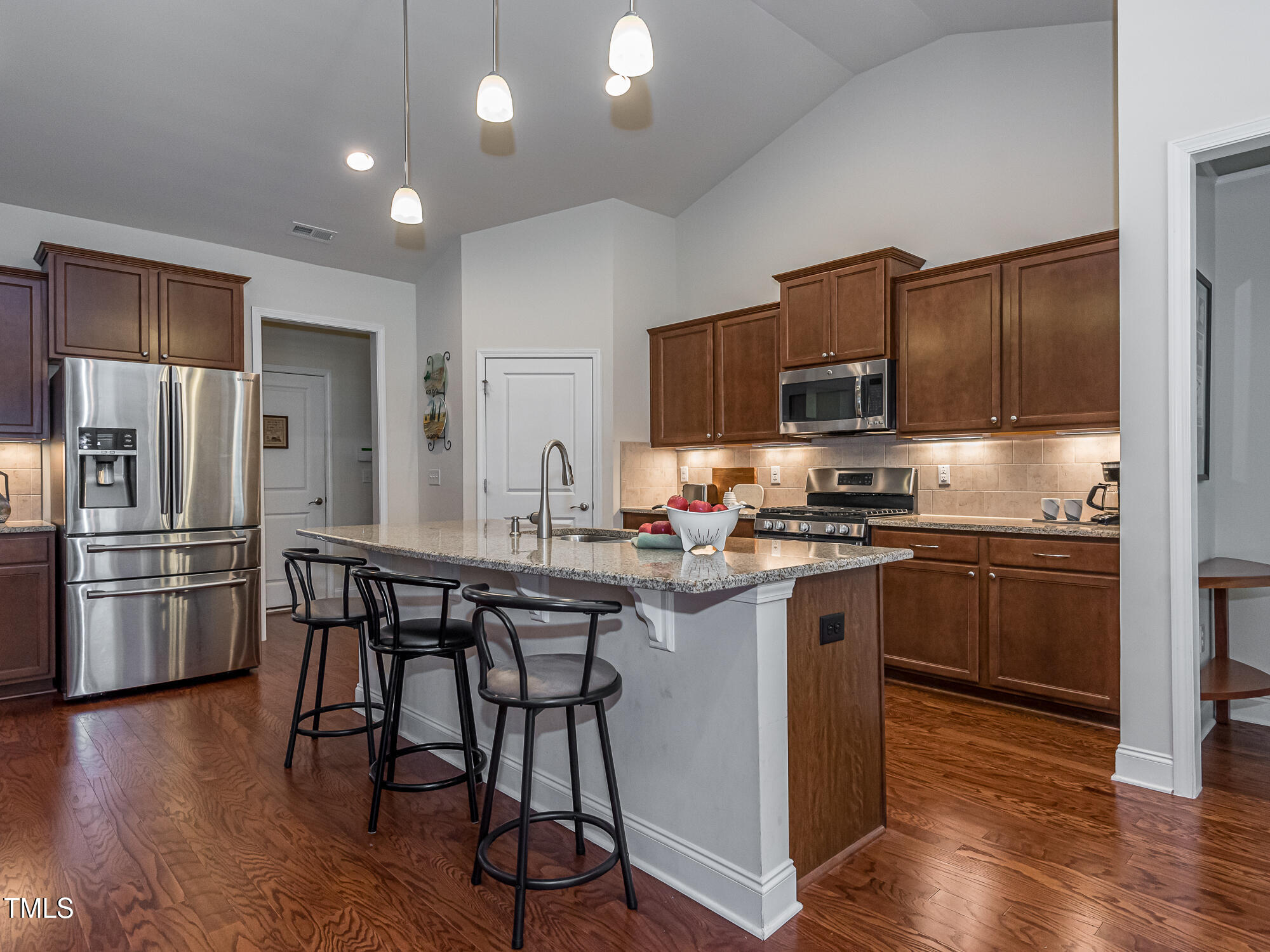 7512 Channery Way Raleigh, NC 27616 - Photo 4 of 45 a kitchen with kitchen island granite countertop stainless steel appliances and wooden cabinets