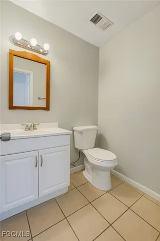 a bathroom with a toilet sink vanity and mirror