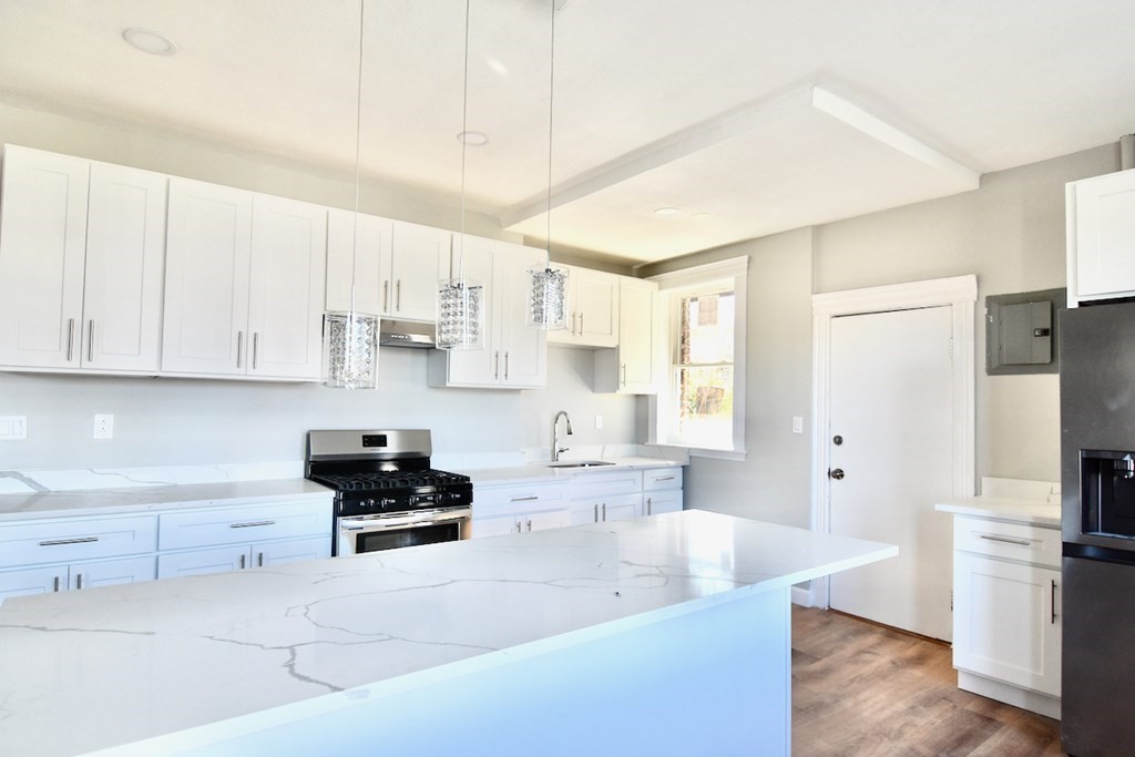 105 Homestead Street, Unit 2 Boston, MA 02121 - Photo 2 of 19 a kitchen with white cabinets and stainless steel appliances