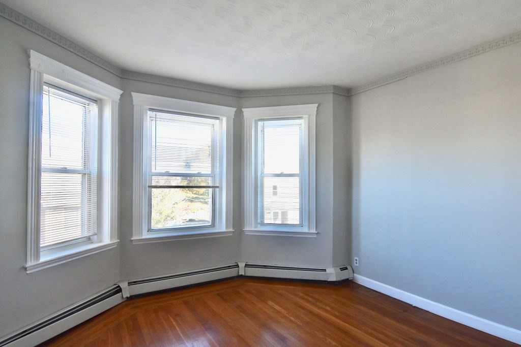 105 Homestead Street, Unit 2 Boston, MA 02121 - Photo 9 of 19 an empty room with wooden floor and windows