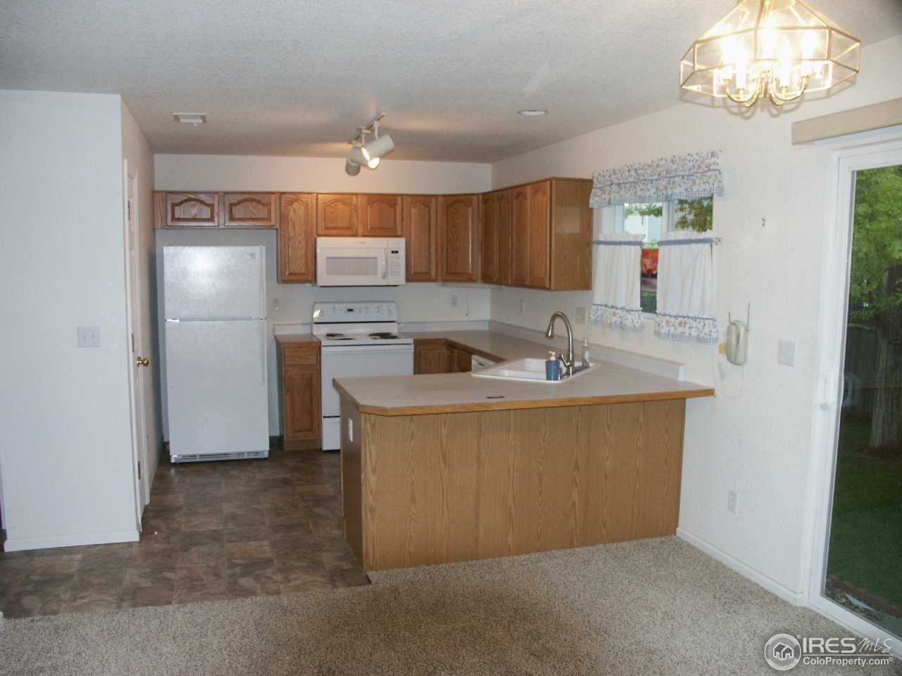 1338 Trail Ridge Road Longmont, CO 80504 - Photo 3 of 13 a kitchen with stainless steel appliances granite countertop a sink a refrigerator and a stove