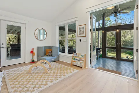 a living room with furniture floor to ceiling window and wooden floor