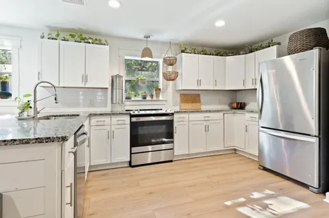 a kitchen with white cabinets stainless steel appliances and sink