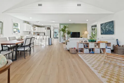 a living room with furniture a flat screen tv and a hard wood floor