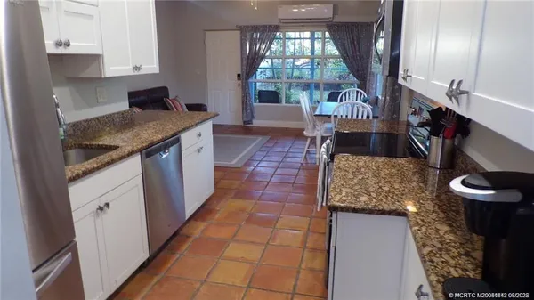 a kitchen with stainless steel appliances granite countertop a sink stove and cabinets