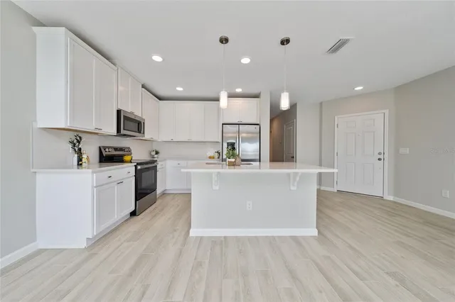 a large kitchen with kitchen island a sink a stove a center island and a window