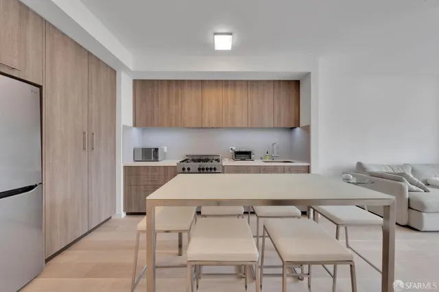 a kitchen with a table chairs and a refrigerator