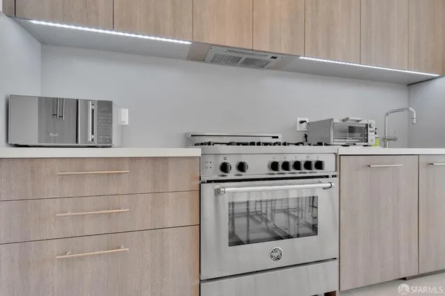 a stove top oven sitting inside of a kitchen