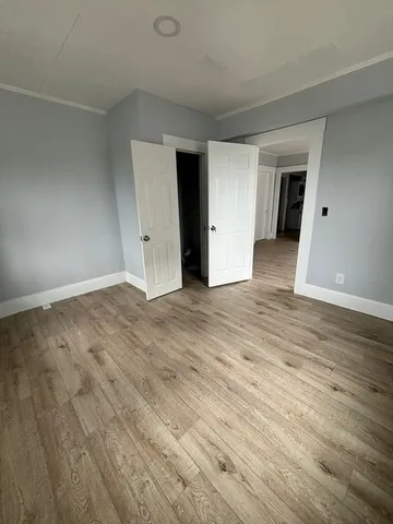 an empty room with wooden floor and closet