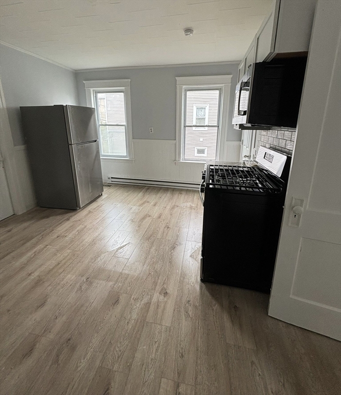 9 Winthrop Street Worcester, MA 01604 - Photo 24 of 30 an empty room with wooden floor cabinet and a window