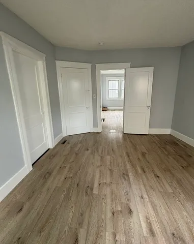 an empty room with wooden floor and closet