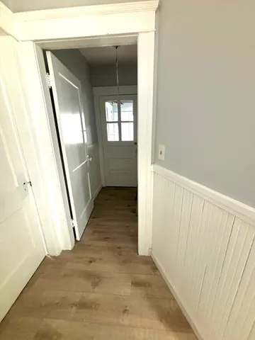 a view of a hallway with wooden floor and staircase