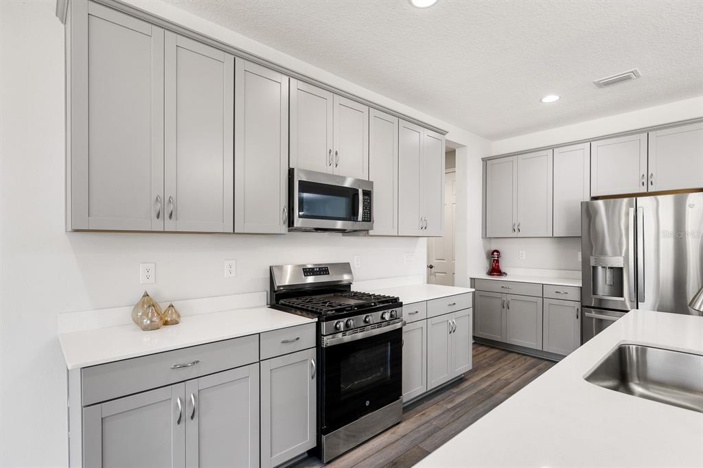 14671 Horse Trot Road Lithia, FL 33547 - Photo 7 of 40 a kitchen with white cabinets sink and stainless steel appliances