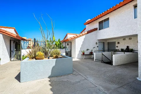 a view of a house with couches and a fire pit