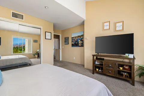 a bedroom with a bed and a flat screen tv
