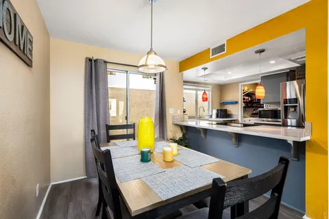 a view of a dining room and livingroom with furniture wooden floor a chandelier