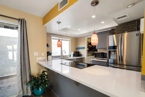 a kitchen with stainless steel appliances a refrigerator sink and stove