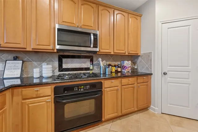 a kitchen with granite countertop cabinets stainless steel appliances and a sink