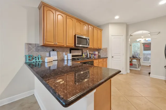 a kitchen with stainless steel appliances granite countertop a sink stove and microwave