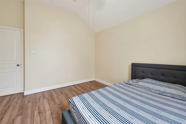 a bedroom with a bed and wooden floor