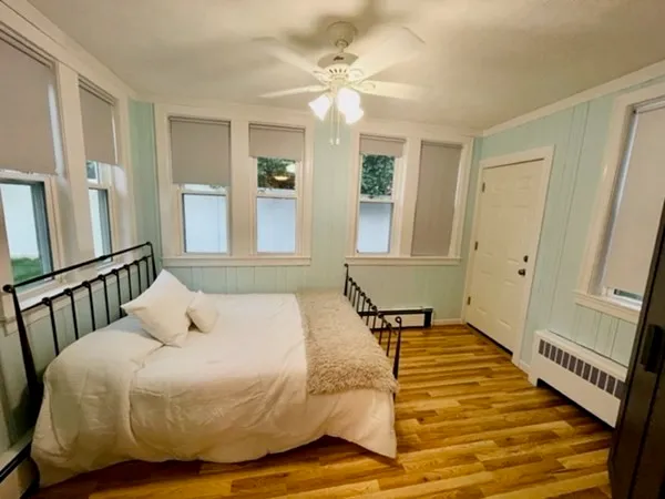 a bedroom with a bed and wooden floor